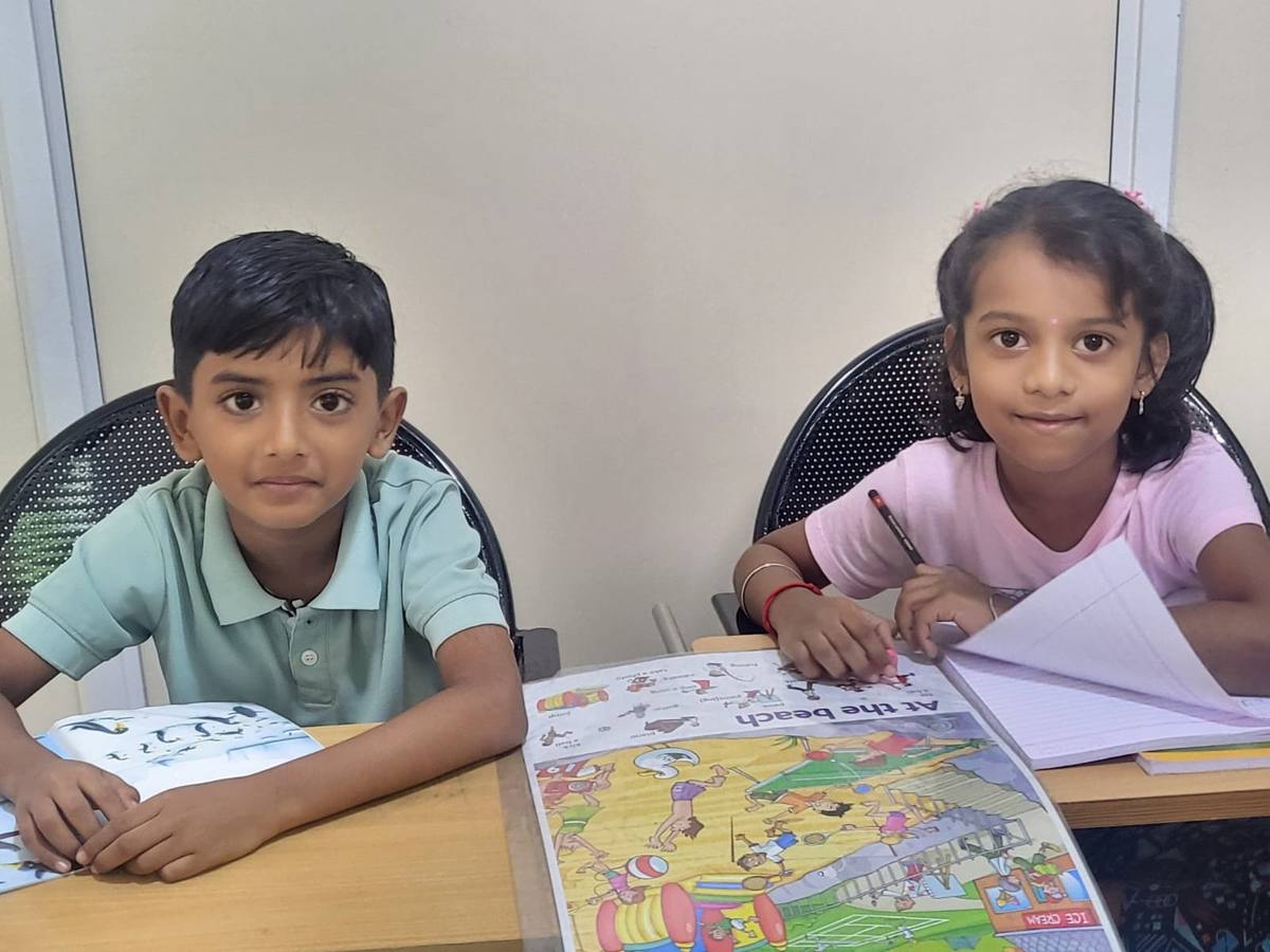 Two students reading a book together in class.